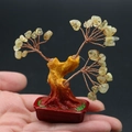 Mini-Geldbaum aus gelbem Naturkristall als Ornament in der Hand zum Größenvergleich - Citrin