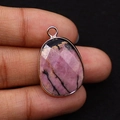 Macro shot of a teardrop-shaped natural pink rhodonite stone pendant with rose gold edging - 17x26mm / Rhodonite with Black Lines