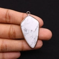 Detailed close-up of shield-shaped white turquoise pendant with gold plated edges - Howlite