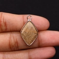 Detailansicht eines facettierten Tigerauge-Anhängers mit Goldbeschichtung in der Hand - 15x25mm 3g/Stück / Jaspis