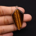 Detailed view of shield-shaped tiger eye stone pendant with rose gold plated edging - Tiger's Eye