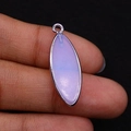 Macro detail of lavender amethyst marquise pendant with silver plated edge held in hand - Opal