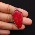 Macro detail of a red shield-shaped natural stone pendant with silver metal plating - Red Agate Style / Red