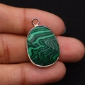 Macro shot of oval malachite stone pendant with rose gold plated edging and small hanging loop - 17x26mm / Malachite