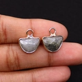 Close-up of semi-circle natural stone pendants with gold plated edges and gray textures - Flash Stone (Labradorite)