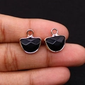 Detailed close-up of a faceted black onyx pendant with rose gold plated metal trim - Black Agate