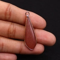 Détail d'un pendentif goutte en pierre naturelle rouge avec bordure en métal doré - 12x36mm / Aventurine violette
