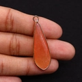 Vue macro d'un pendentif en pierre naturelle orange en forme de goutte et bordure dorée - 12x36mm / Style 1 (Orange)