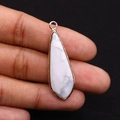 Gros plan détaillé d'un pendentif en pierre blanche en forme de goutte et bordure dorée - 12x36mm / Howlite