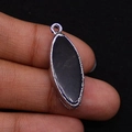 Marquise shaped black agate pendant with silver textured metal frame on hand - Black Agate