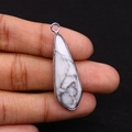 Close-up of white marble teardrop pendant with silver metal border held in hand - 12x38mm 4g/pc / Howlite