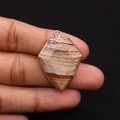 Close-up of shield-shaped jasper stone pendant with gold metal edges held in hand - 22x30mm / Jasper