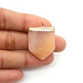 Nahaufnahme von Naturstein-Schwertanhänger in Orange mit goldener Öse in der Hand gehalten - Schwertform (Modell: 20x30mm) / Rosa Aventurin