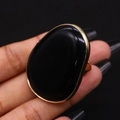 Macro shot of large irregular black agate ring with polished gold-plated metal border - 30x41mm / Black Agate