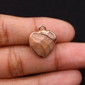 Pendentif cœur en pierre naturelle brune avec bordure en métal doré sur doigt - Jaspe