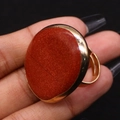 Macro detail of the adjustable gold plated ring with a large round red natural stone - 30x41mm / Red Jasper
