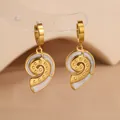 Boucles d'oreilles spirale dorées avec émail blanc et pendentifs élégants à pampilles - Conque / Blanc