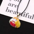 Détail macro d'un pendentif coquillage peint à la main avec bords dorés sur cordon noir - Style Peint Coloré Rouge Jaune et Bleu (N° 1)