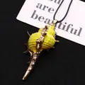 Macro detail of a conch shell pendant with fluorescent yellow coating and gold-plated edges - Conch Pendant With Cord / Fluorescent Yellow (No. 1)