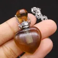 Macro shot of a heart-shaped gemstone perfume bottle necklace being held by hand - 23x36mm, 15g / Smoky Quartz