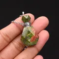 Detailed macro of unakite stone perfume bottle pendant with faceted cut on silver chain - 19x35mm / Unakite