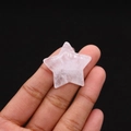 Macro view of a small star-shaped rose quartz crystal stone held by a hand - 30mm (Thickness 8mm) / White Crystal