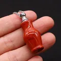 Pendentif flacon de parfum en jaspe rouge avec bouchon argenté tenu sur fond noir - Jaspe Rouge