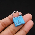 Macro shot of turquoise stone heart lock pendant with silver wire-wrapped detailing - Blue Turquoise