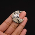 Makroaufnahme einer mondförmigen Dalmatiner-Jaspis-Steinperle zwischen den Fingern - 27x30mm (Dicke 8mm) / Dalmatinerjaspis