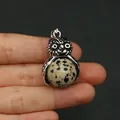 Dettaglio del ciondolo a civetta in metallo argento retrò e pietra naturale macchiata - Pietra Dalmata