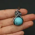 Dettaglio di un ciondolo a forma di gufo in argento con pietra turchese rotonda - Turchese blu