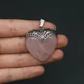 Nahaufnahme eines Herzanhängers aus Rosenquarz mit verzierten silbernen Beschlägen - Rosenquarz