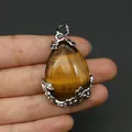 Detailansicht der Tropfenform Tigerauge Anhänger mit floraler Fassung in Silberoptik - 28x41mm