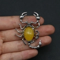 Detailed close-up of a handmade scorpion pendant with natural tiger eye stone inlay - No.2 (Amber Yellow)