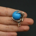 Macro shot of gold dragon claw pendant holding a blue stone for DIY necklace jewelry - Dark Blue Turquoise