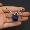 Spider pendant with blue sphere gemstone in silver metal frame held by hand - 34x47mm, 14g / Enhanced Lapis Lazuli