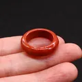 Polished natural dark red agate stone band ring worn on finger with black background - Red Jasper