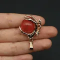 Detail view of golden dragon claw pendant holding a red stone ball with scale textures - Watermelon Quartz