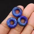 Drei tiefblaue Lapislazuli Donut-Perlen mit goldenen Pyrit-Punkten in der Hand - 16mm / Lapislazuli