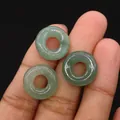 Drei polierte Donut-Perlen aus grünem Aventurin zur Größendarstellung auf dem Finger - 16mm / Grüner Aventurin