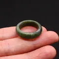 Natural dark green jade ring with polished smooth finish worn on finger - Serpentine
