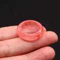 Polished translucent light pink natural crystal quartz ring shown on fingertips - Watermelon Quartz