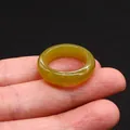 Translucent yellow-green agate ring in a classic round band design shown in hand - Yellow Xiuyan Jade