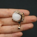 Golden dragon claw pendant featuring a polished milky white gemstone on a neutral background - White Jade