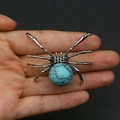 Silver spider pendant with a large turquoise stone centerpiece held in hand - 34x47mm, 14g / Blue Turquoise