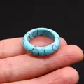 Polished sky blue turquoise style stone ring with black marble texture held by hand - Blue Turquoise