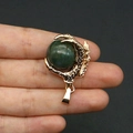 Golden dragon claw pendant featuring a polished dark green stone ball on dark background - US 8