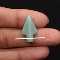 Macro detail van een turquoise pijlpunt hanger in de hand gehouden tegen zwarte achtergrond - Groene Aventurijn