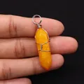 Close-up of yellow hexagonal crystal pendant wrapped in silver wire held by hand - 10x40mm / Yellow (No. 5)