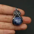 Ciondolo gufo argentato con pietra naturale blu tenuto per confronto dimensioni - Sodalite